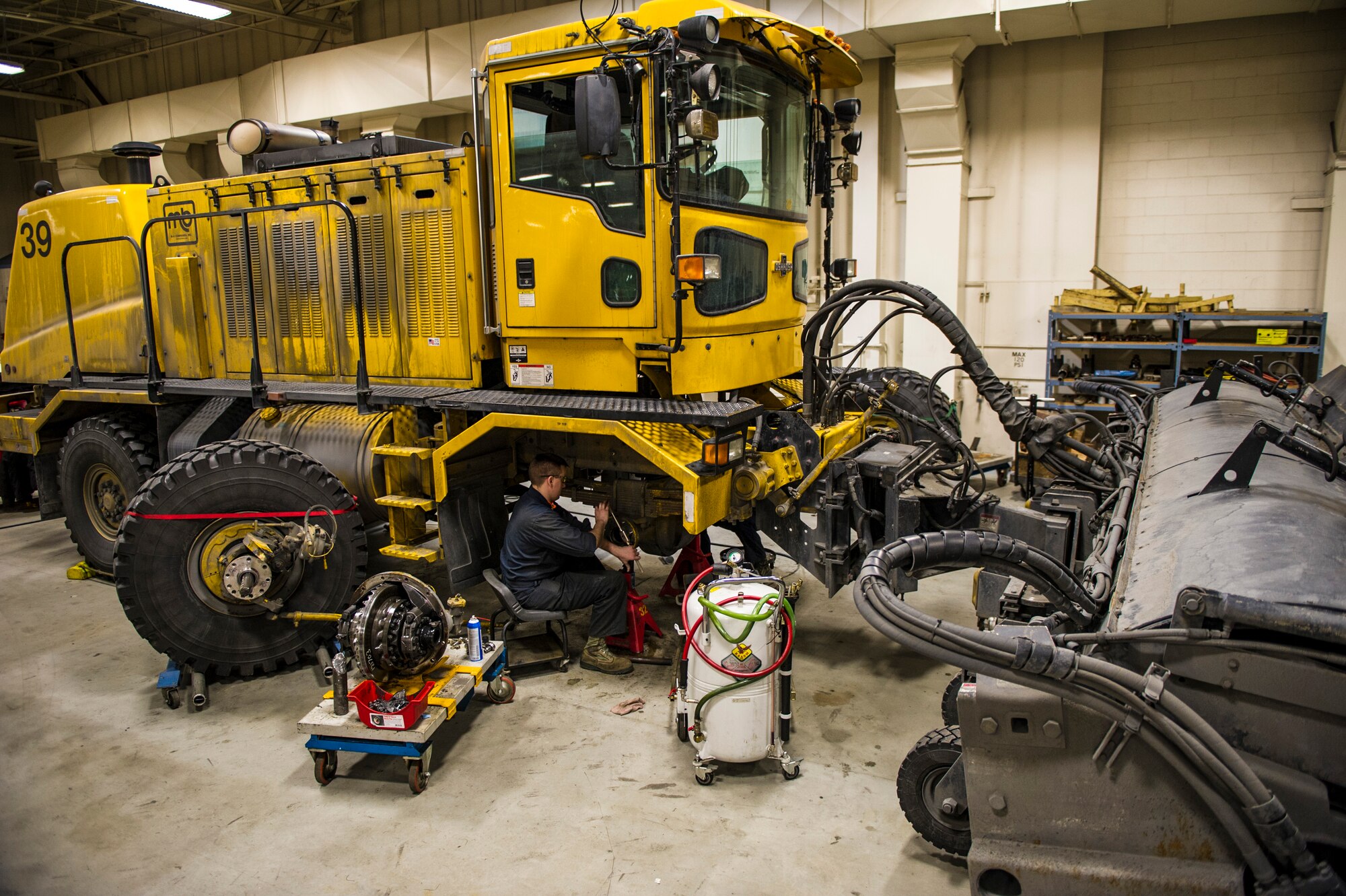 U.S. Air Force Senior Airman Anthony Tavares, 354th Logistics Readiness Squadron vehicle maintenance journeyman, cleans the front axle housing of a flightline snow broom Jan. 8, 2014, Eielson Air Force Base, Alaska. Winter months can cover the base with snow and ice, requiring snow removal operations all week long. The 354th LRS perform maintenance on vehicles to ensure the 354th Fighter Wing mission is unhindered. (U.S. Air Force photo by Senior Airman Joshua Turner/Released)