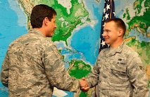 PETERSON AIR FORCE BASE, Colo. – Col. Courtney Arnold, left, 302nd Airlift Wing commander, recognizes Senior Airman Michael Scholl with a coin during the wing’s unit training assembly Jan. 12, 2014.  Arnold, who assumed command after Col. Jay Pittman deployed to southwest Asia, spent part of his UTA visiting different squadrons around the 302nd AW, where he recognized superior achievements of the wing’s Airmen. Scholl was a distinguished graduate during vehicle maintenance technical school and is currently a Logistic Readiness Squadron vehicle mechanic. (U.S. Air Force photo/Staff Sgt. Nathan Federico)