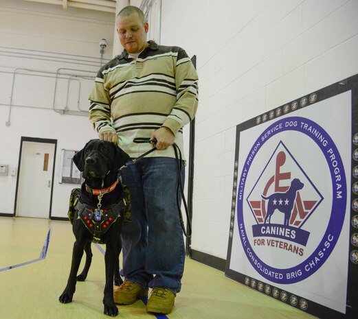 Retired Marine Cpl. Christopher Owens stands with his new service dog, Samaria, during a ceremony Jan. 9, 2014, at the Naval Consolidated Brig Charleston at Joint Base Charleston – Weapons Station. Samaria trained for more than a year at the NCBC as part of the Carolina Canines for Service program. CCFS is a non-profit health and human services organization that trains service dogs for veterans with disabilities. (U.S. Air Force photo/Airman 1st Class Clayton Cupit)