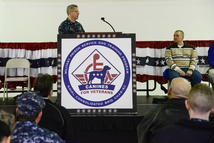 Cmdr. Patrick Boyce, Naval Consolidated Brig Charleston commanding officer, welcomes guests Jan. 9, 2014, during a ceremony at the Naval Consolidated Brig Charleston, at Joint Base Charleston – Weapons Station. Carolina Canines for Service is a non-profit health and human services organization that trains service dogs for veterans with disabilities. (U.S. Air Force photo/Airman 1st Class Clayton Cupit)