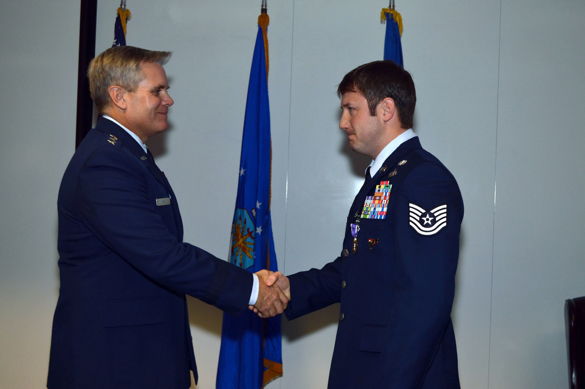 Lt. Gen. Eric Fiel, Air Force Special Operations Command commander, awards the Purple Heart medal to Tech. Sgt. Jeremy Whiddon, 21st Special Tactics Squadron, Jan. 10, 2014, at Pope Army Airfield, Fort Bragg, N.C., for wounds received in action on May 29, 2013. (U.S. Air Force photo by Marvin Krause)