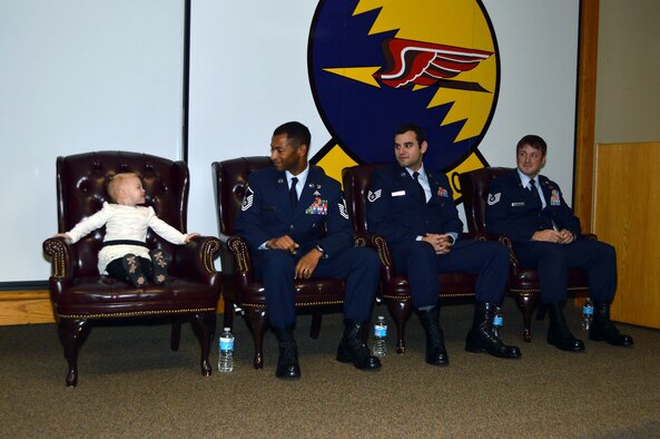 Master Sgt. Delorean Sheridan smiles at his daughter Kinsley, while Staff Sgt. Christopher Baradat and Tech. Sgt. Jeremy Whiddon look on during a 21st Special Tactics Squadron awards ceremony, presided by Lt. Gen. Eric Fiel, Air Force Special Operations Command commander, who awarded Silver Star medals to Sheridan and Baradat and a Purple Heart medal to Whiddon, Jan. 10, 2014, at Pope Army Airfield, Fort Bragg, N.C. (U.S. Air Force photo by Marvin Krause)