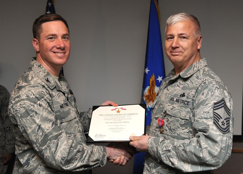 Chief Master Sgt. Robert Wege, 5th Maintenance Squadron, is presented the Bronze Star by Col. Alex Mezynski, 5th Bomb Wing commander, during a presentation here, Jan. 13, 2014. The Bronze Star Medal is the fourth-highest individual military award and the ninth-highest by order of precedence in the U.S. military. Wege was awarded for meritorious service while serving overseas in 2013. (U.S. Air Force photo/Airman 1st Class Andrew Crawford)