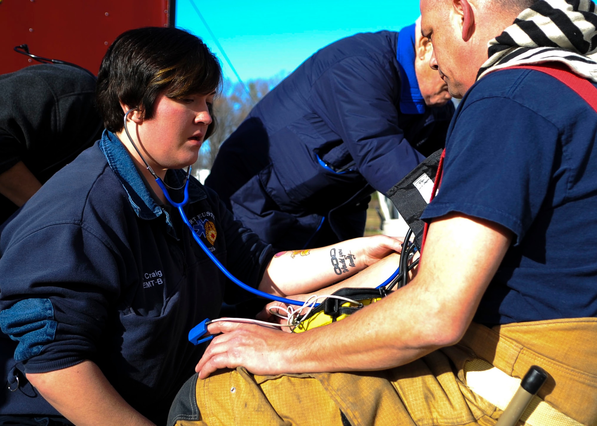 J. Blanchette, 733rd Civil Engineer Division supplemental emergency medical technician, checks a firefighter's vitals during a hazardous material exercise at Fort Eustis, Va., Dec. 11, 2013. The training areas at Fort Eustis allow personnel to conduct various exercises, ranging from amphibious assaults to simulated chemical spills. (U.S. Air Force photo by Airman 1st Class Austin Harvill/Released) 
