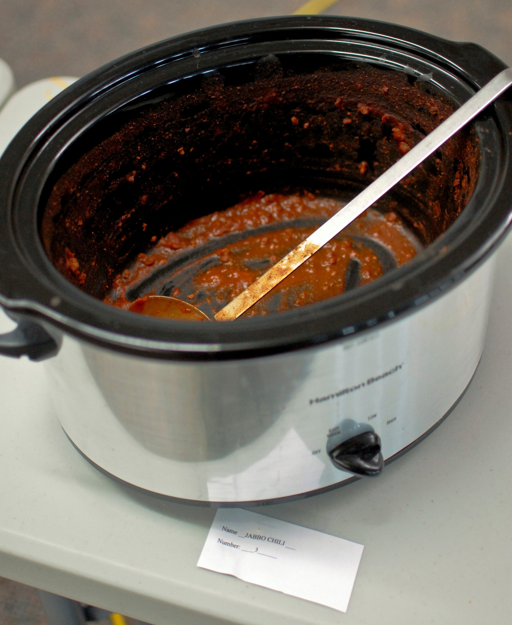 A crockpot of U.S. Air Force Tech Sgt. Alex R. Sea’s award-winning Jabbo Chili sits empty after the sixth-annual chili cook off at the 182nd Airlift Wing, Peoria, Ill., Jan. 8, 2014. The competition placed 13 contestants and their homemade chili recipes against each other to compete for best look and smell, best consistency, and best taste. Sea, a vehicle equipment maintenance specialist with the 182nd Logistics Readiness Squadron, won in both the best consistency and most overall points categories. He was awarded a five-year membership to the wing’s consolidated club and had his name added to the plaque of winners. The event brought out approximately 120 unit members to sample the various white and traditional red entries, and raised $490 in support of operating the wing’s consolidated club. Sea enjoys the yearly event because he gets to have good chili with good people, he said. “It’s a good way to get out and mingle and talk to the people you don’t usually see on a day-to-day basis.” (U.S. Air National Guard photo by Staff Sgt. Lealan Buehrer/Released. Image was cropped to emphasize subject.)