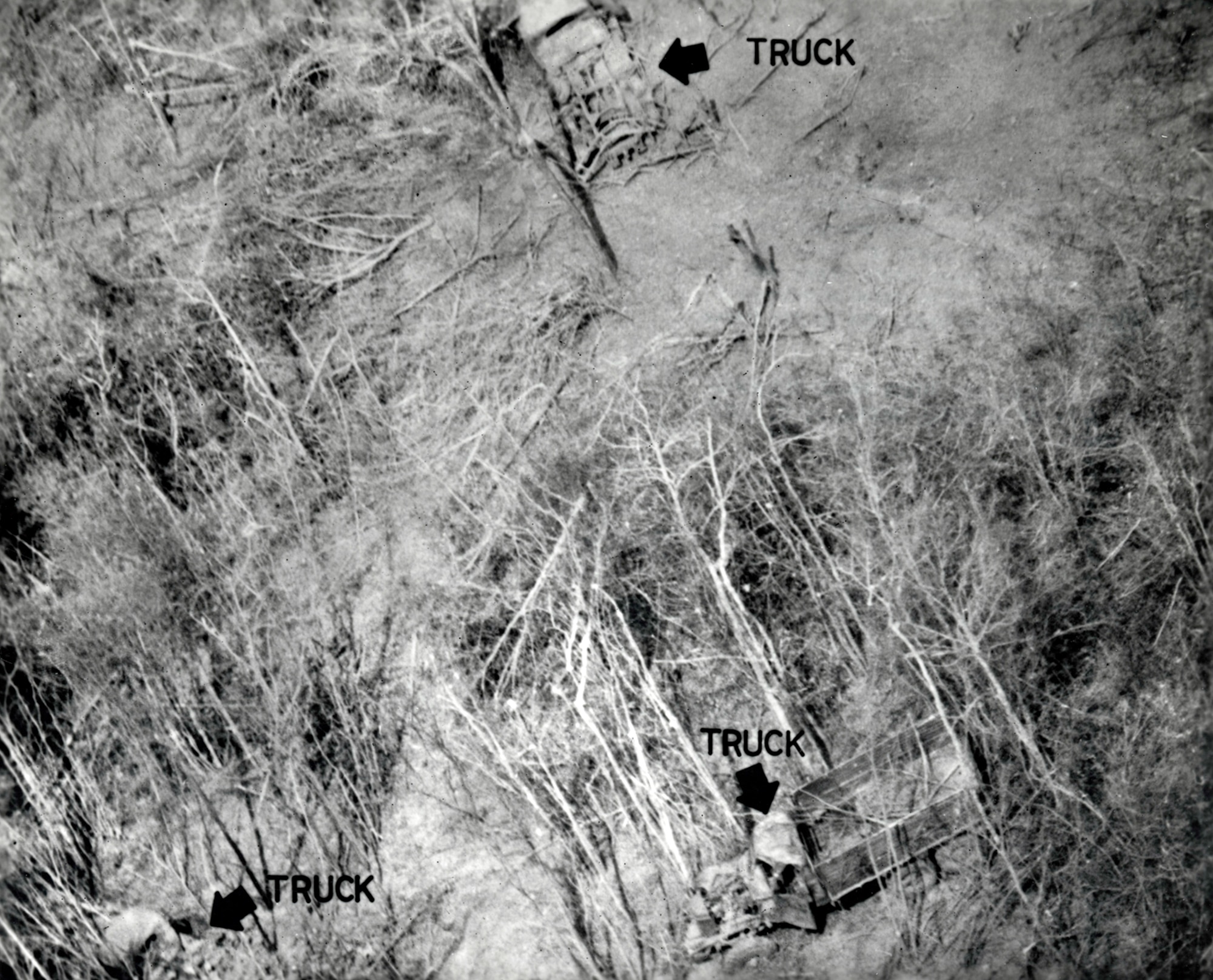 Photograph taken on an RF-4C mission, showing three burned-out communist trucks. The RF-4Cs could take photographs day or night using optical cameras, infrared cameras or radar. (U.S. Air Force photo)
