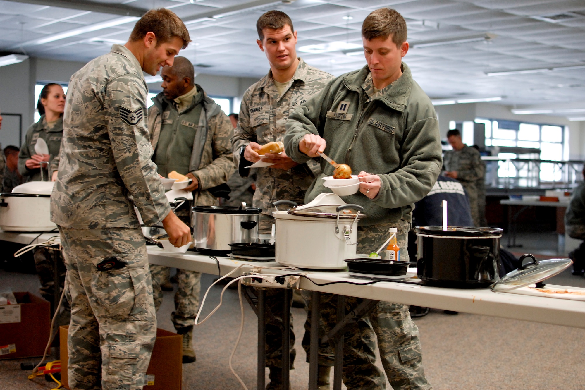 Airmen of the 182nd Airlift Wing sample chili during the sixth-annual chili cook off at the 182nd Airlift Wing, Peoria, Ill., Jan. 8, 2014. The competition placed 13 contestants and their homemade chili recipes against each other to compete for best look and smell, best consistency, and best taste. The event brought out approximately 120 unit members to sample the various white and traditional red entries, and raised $490 in support of operating the wing’s consolidated club. U.S. Air Force Tech. Sgt. Alex R. Sea, vehicle equipment maintenance specialist and winner of the 2014 competition, enjoys the yearly event because he gets to have good chili with good people, he said. “It’s a good way to get out and mingle and talk to the people you don’t usually see on a day-to-day basis.” (U.S. Air National Guard photo by Staff Sgt. Lealan Buehrer/Released. Image was cropped to emphasize the subjects.)