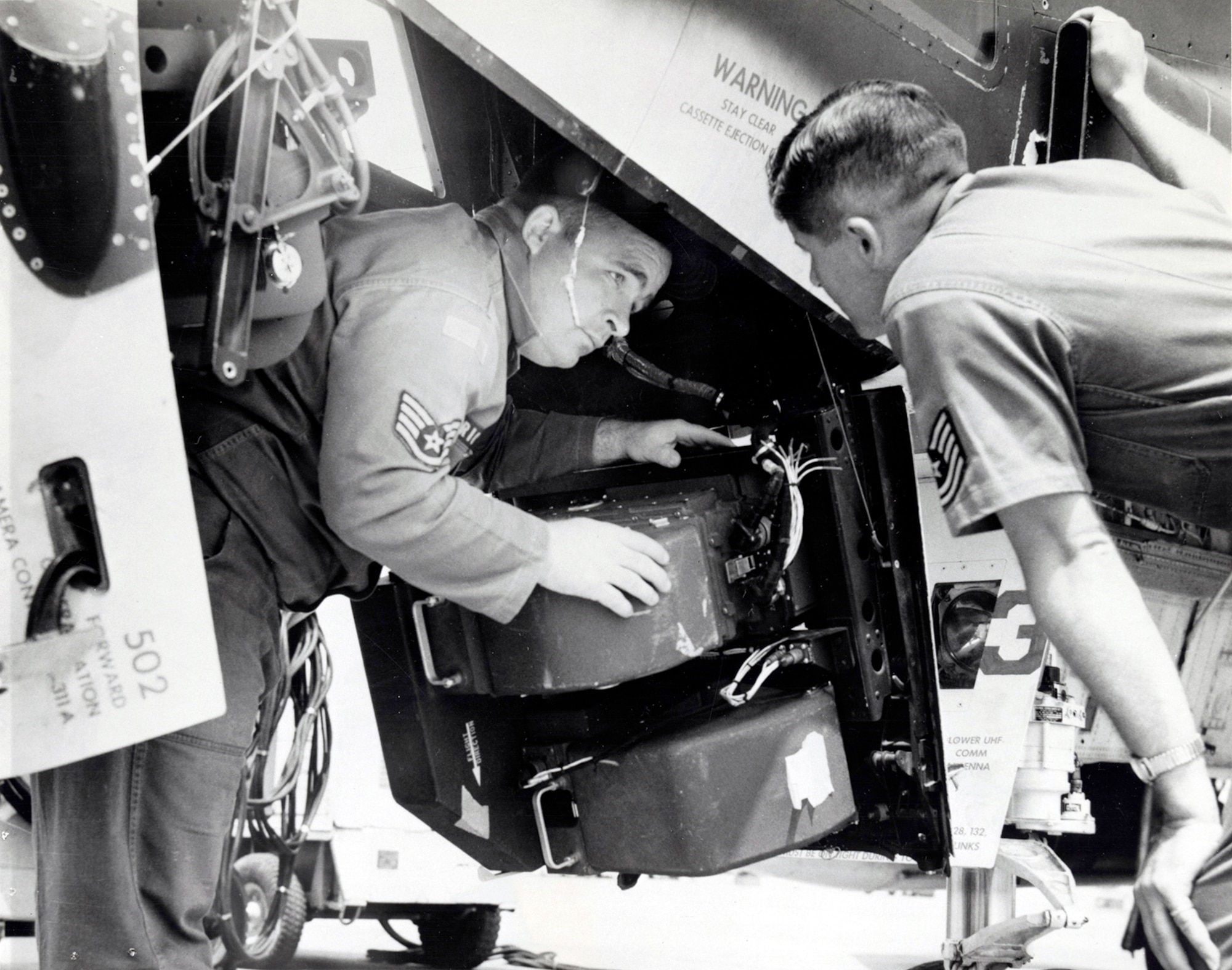 Camera technicians Staff Sgt. Gerald Richey (left) and Tech. Sgt. Harold Cockrum quickly retrieve film from an RF-4C. Rapid photo processing, analysis and distribution were top priorities. (U.S. Air Force photo)
