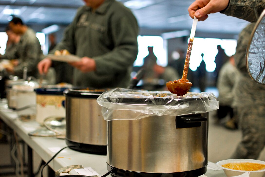 Airmen of the 182nd Airlift Wing sample chili during the sixth-annual chili cook off at the 182nd Airlift Wing, Peoria, Ill., Jan. 8, 2014. The competition placed 13 contestants and their homemade chili recipes against each other to compete for best look and smell, best consistency, and best taste. The event brought out approximately 120 unit members to sample the various white and traditional red entries, and raised $490 in support of operating the wing’s consolidated club. U.S. Air Force Tech. Sgt. Alex R. Sea, vehicle equipment maintenance specialist and winner of the 2014 competition, enjoys the yearly event because he gets to have good chili with good people, he said. “It’s a good way to get out and mingle and talk to the people you don’t usually see on a day-to-day basis.” (U.S. Air National Guard photo by Staff Sgt. Lealan Buehrer/Released)