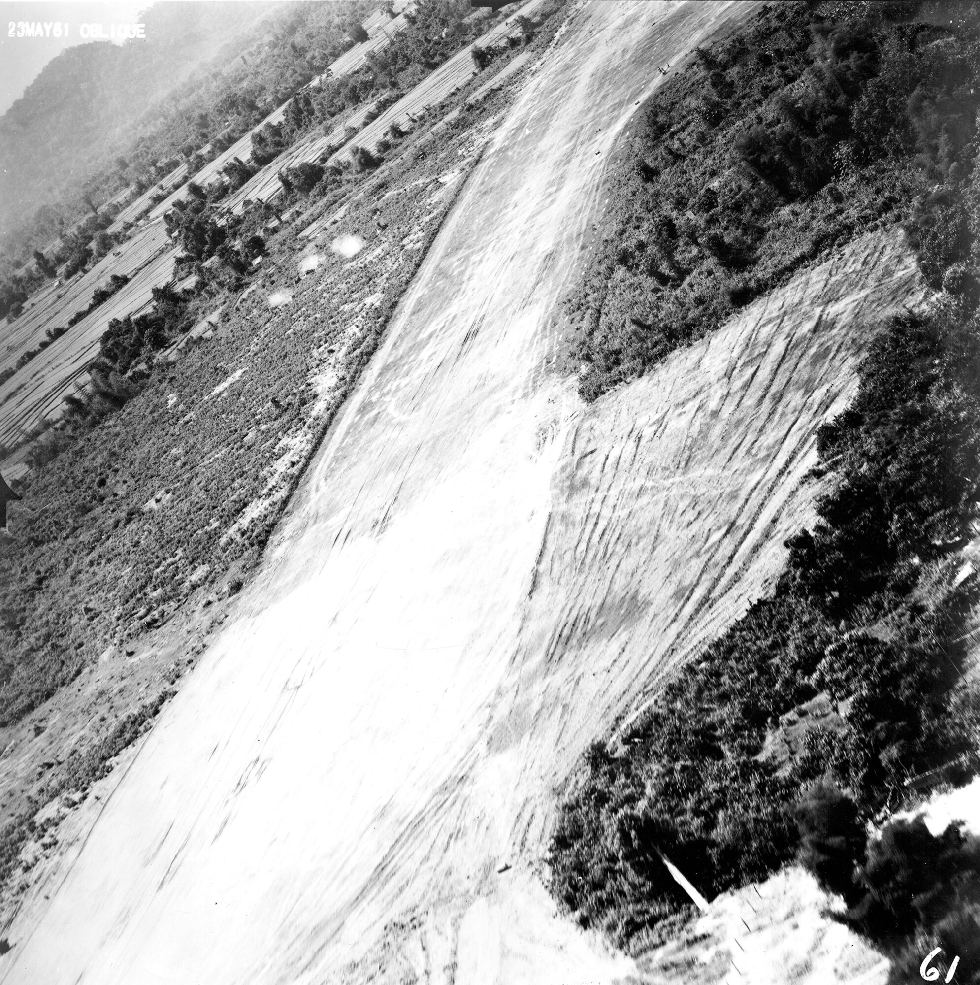 Reconnaissance image of Vang Vieng airfield, Laos, from a PROJECT FIELD GOAL flight in May 1961. At the time, the Soviets were using this airstrip to resupply Pathet Lao insurgents. Visible in the photo is smoke from three anti-aircraft guns firing at the RT-33A. (U.S. Air Force photo)