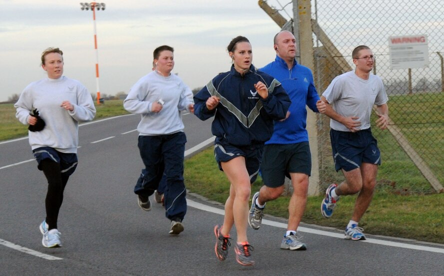 Team Mildenhall members approach the final stretch of the wing run Jan. 10, 2014, on RAF Mildenhall, England. The monthly 5 km run encourages morale and camaraderie throughout the base through exercise and healthy competition. Each month, members of the 100th ARW gather near the Hardstand Fitness Center to exercise together as a team. (U.S. Air Force photo by Airman 1st Class Jonathan Light/Released)