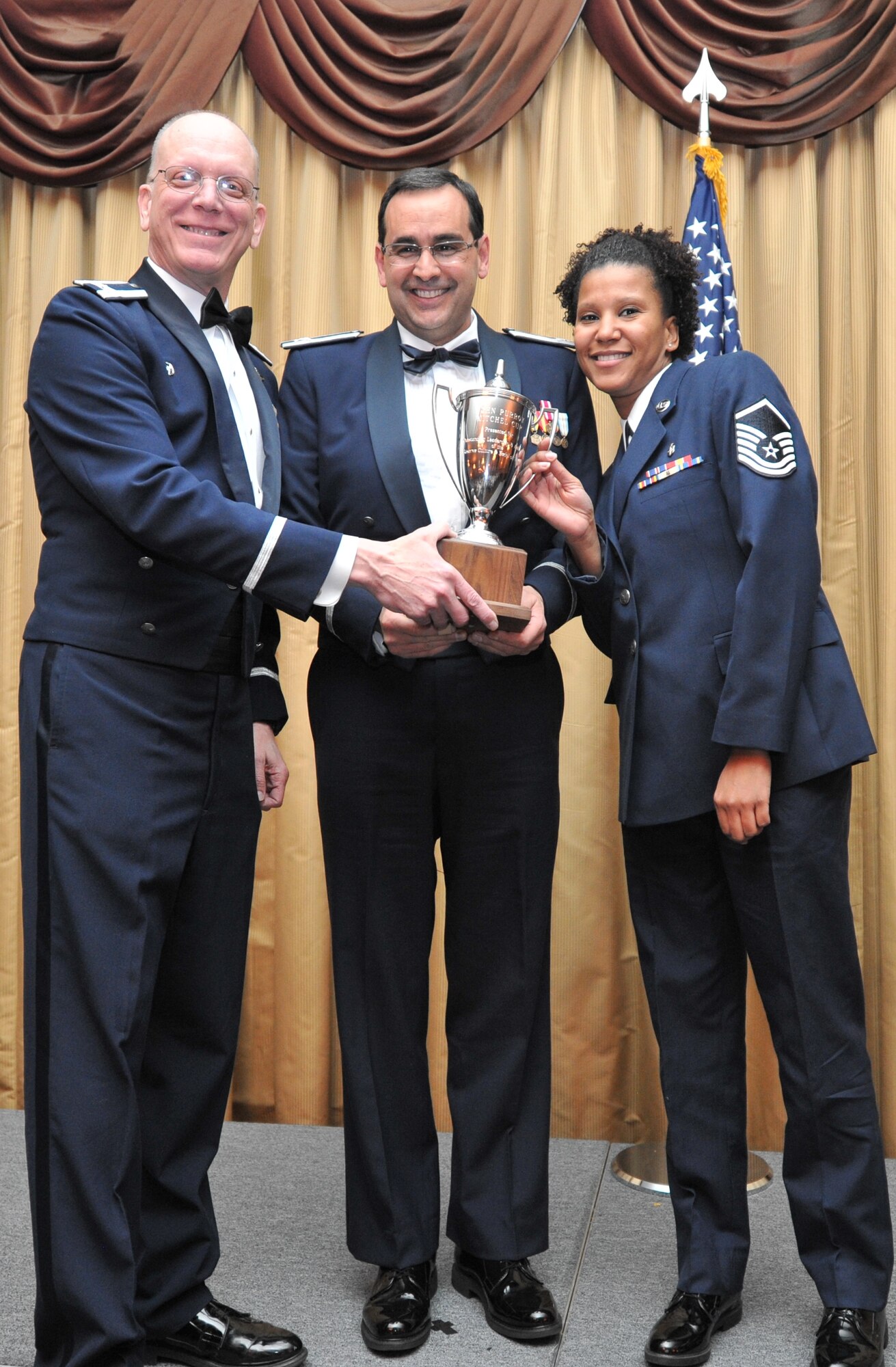 Col. Thomas J. Pizzolo, 514th Aerospace Medicine Squadron commander, and Master Sgt. Vanity N. Day of the 514th AMDS accept the Mitchel Cup Award on behalf of the entire squadron at the 14th Annual Awards Banquet held at Tommy B’s Community Center here Jan. 11 (U.S. Air Force photo/Senior Airman Chelsea Smith).