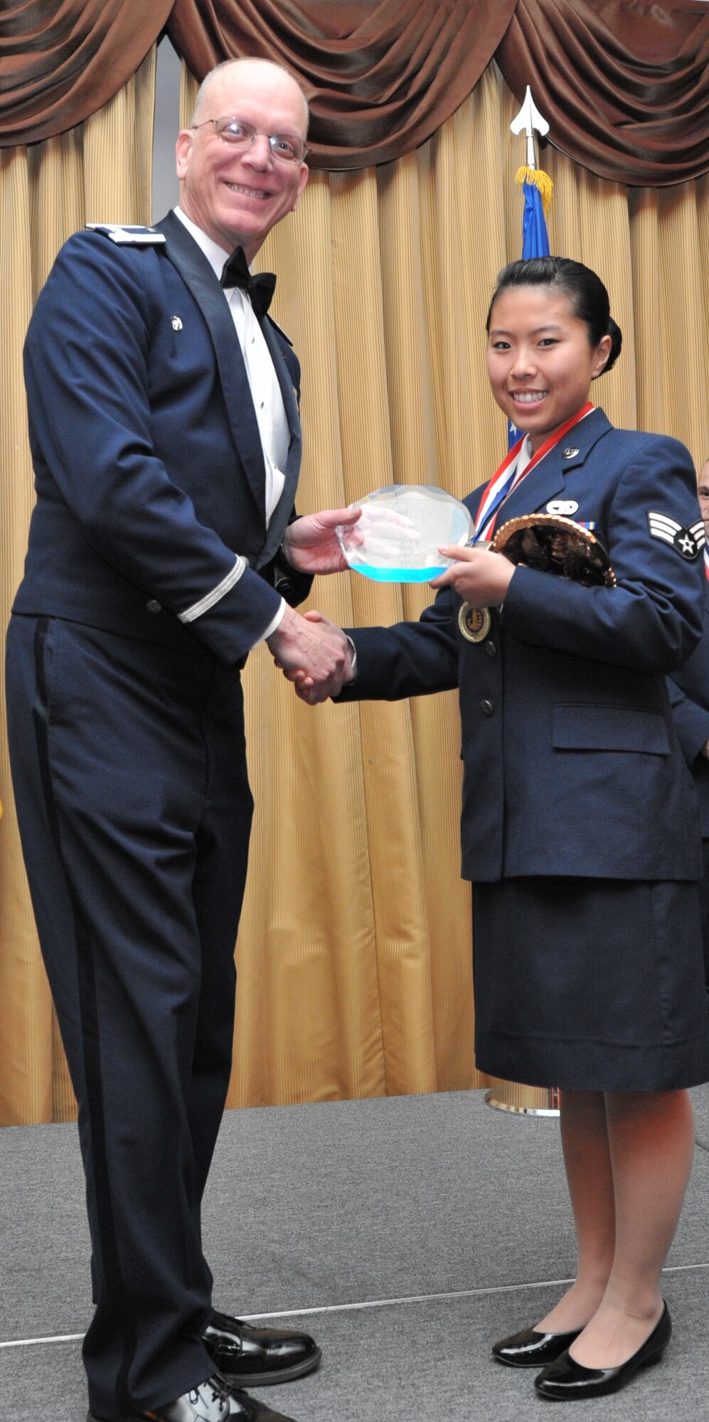 Senior Airman Sara Kim of the 35th Aerial Port Squadron receives the Airman of the Year award at the 14th Annual Awards Banquet held at Tommy B’s Community Center here Jan. 11. Members here are nominated from within their ranks to be recognized at the annual event. Winners are then forwarded to compete with other units within the numbered Air Force (U.S. Air Force photo/Senior Airman Chelsea Smith).