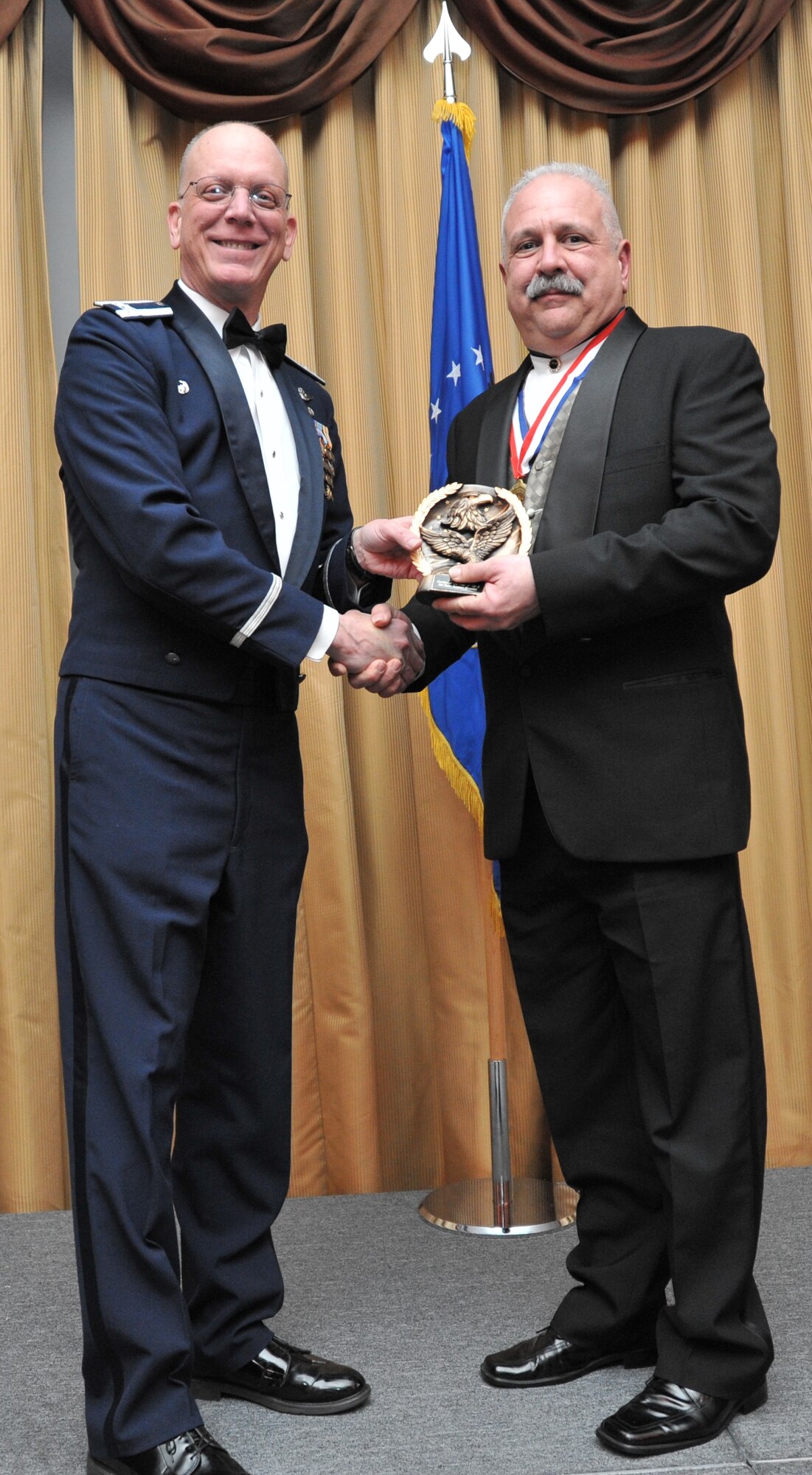 Carl Schmidt, right, of the 514th Force Support Squadron receives the category 2 civilian award at the 14th Annual Awards Banquet held at Tommy B’s Community Center here Jan. 11. Col. Michael Underkofler, 514th AMW commander, presented 12 prestigious awards at the ceremony to recognize the outstanding achievements of Freedom Wing Airmen and civilian personnel, as well as the efforts of 514th AMW squadrons and groups (U.S. Air Force photo/Senior Airman Chelsea Smith). 