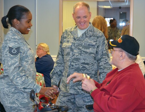 WRIGHT-PATTERSON AIR FORCE BASE, Ohio - Tech. Sgt. Crystal Tyson., 445th Aeromedical Staging Squadron, and Master Sgt. Jeffrey Spires,  445th Logistics Readiness Squadron, share a laugh while exchanging stories with a vet at the  Dayton Veteran Affairs Medical Center. The 445th Airlift Wing visits the medical center every year right around holiday season to help serve food and had out gifts to the veterans that live there.  (U.S. Air Force photo/Senior Airman Matthew Cook)