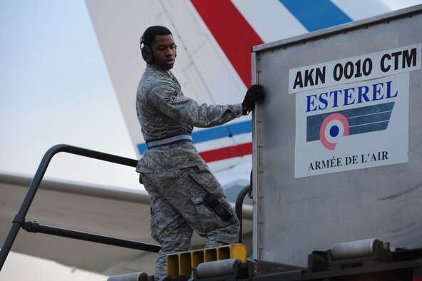 Airman 1st Class Christen Andrews, 728th Air Mobility Squadron aircraft services, monitors the downloading of cargo boxes onto a 60k loader Jan. 9, 2014, at Incirlik Air Base, Turkey. The cargo arrived along with more than 100 German soldiers who will continue to Kahramanmaras, Turkey to replace the German personnel who have been deployed there to man two Patriot missile batteries in support of NATO’s commitment to enhance Turkish air defenses against Syrian aggression. The 728th AMS and 39th Air Base Wing continue to provide a variety of support to U.S., Dutch and German NATO personnel through aircraft and personnel processing, transportation, lodging and morale and welfare services. (U.S. Air Force photo illustration by 1st Lt. David Liapis/Released)