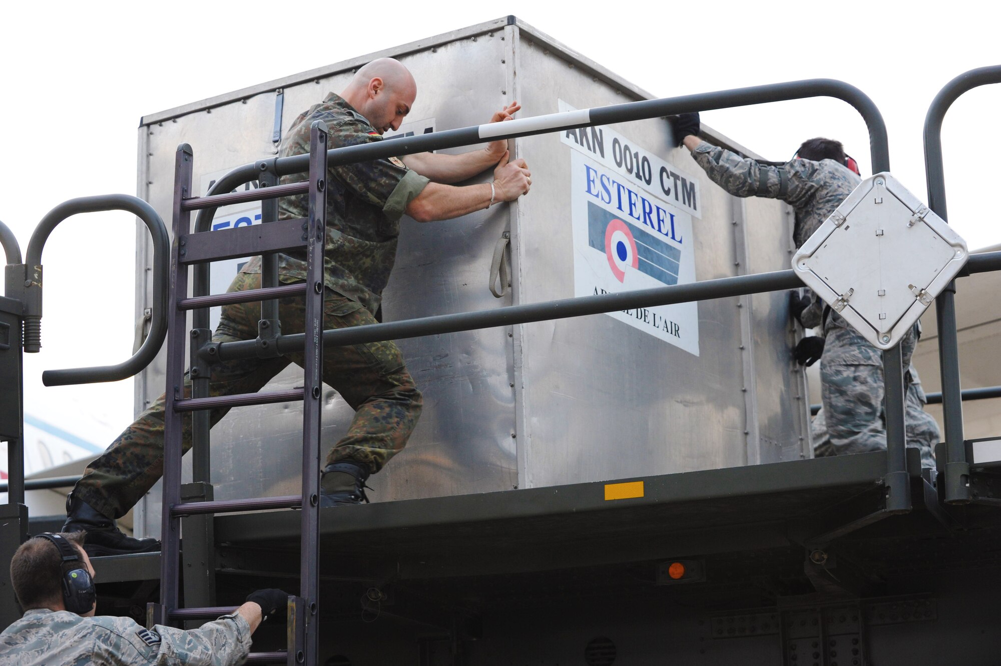 U.S. Air Force Airmen from the 728th Mobility Squadron and a member of the German Army download cargo onto a 60k loader at Jan. 9, 2014, Incirlik Air Base, Turkey. More than 100 German soldiers and associated cargo will be transported to Kahramanmaras, Turkey where they will assume responsibility for manning two Patriot missile batteries. The German government recently approved a year-long extension for German support of the ongoing NATO mission to increase Turkey’s air defense capabilities against Syrian ballistic missile threats. (U.S. Air Force photo illustration by 1st Lt. David Liapis/Released)