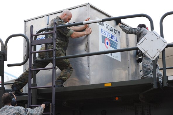 U.S. Air Force Airmen from the 728th Mobility Squadron and a member of the German Army download cargo onto a 60k loader at Jan. 9, 2014, Incirlik Air Base, Turkey. More than 100 German soldiers and associated cargo will be transported to Kahramanmaras, Turkey where they will assume responsibility for manning two Patriot missile batteries. The German government recently approved a year-long extension for German support of the ongoing NATO mission to increase Turkey’s air defense capabilities against Syrian ballistic missile threats. (U.S. Air Force photo illustration by 1st Lt. David Liapis/Released)