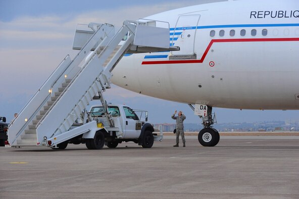 Airman 1st Class William Kooyman, 728th Air Mobility Squadron passenger services technician, marshals a staircase truck up to a French air force Airbus A310 that landed at Incirlik Air Base, Turkey with a troop of German soldiers Jan. 9, 2014. The 728th AMS has been providing support to the NATO Patriots to Turkey mission for more than a year. The soldiers aboard this aircraft will travel to Kahramanmaras, Turkey where they will replace deployed German soldiers currently manning two Patriot missile batteries set up to increase Turkey’s air defense capabilities against Syrian ballistic missile threats. (U.S. Air Force photo by 1st Lt. David Liapis/Released)