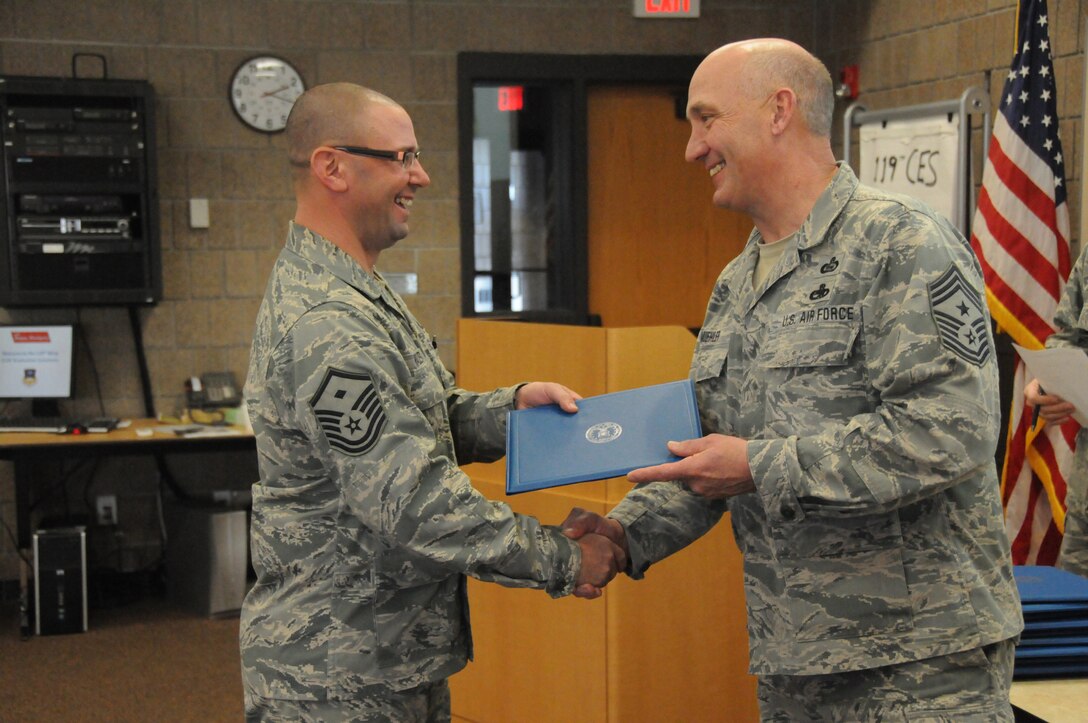 Chief Master Sgt. Kevin Muehler, the 119th Wing command chief, right, presents the Community College of the Air Force degree to Master Sgt. Christopher Walberg, the 119th Mission Support Group first sergeant, during a ceremony at the North Dakota Air National Guard base, Fargo, N.D., Jan. 12, 2013. The community College of the Air Force degree is now required for enlisted personnel to be eligible for promotion to the ranks of Senior Master Sergeant and Chief Master Sergeant. 