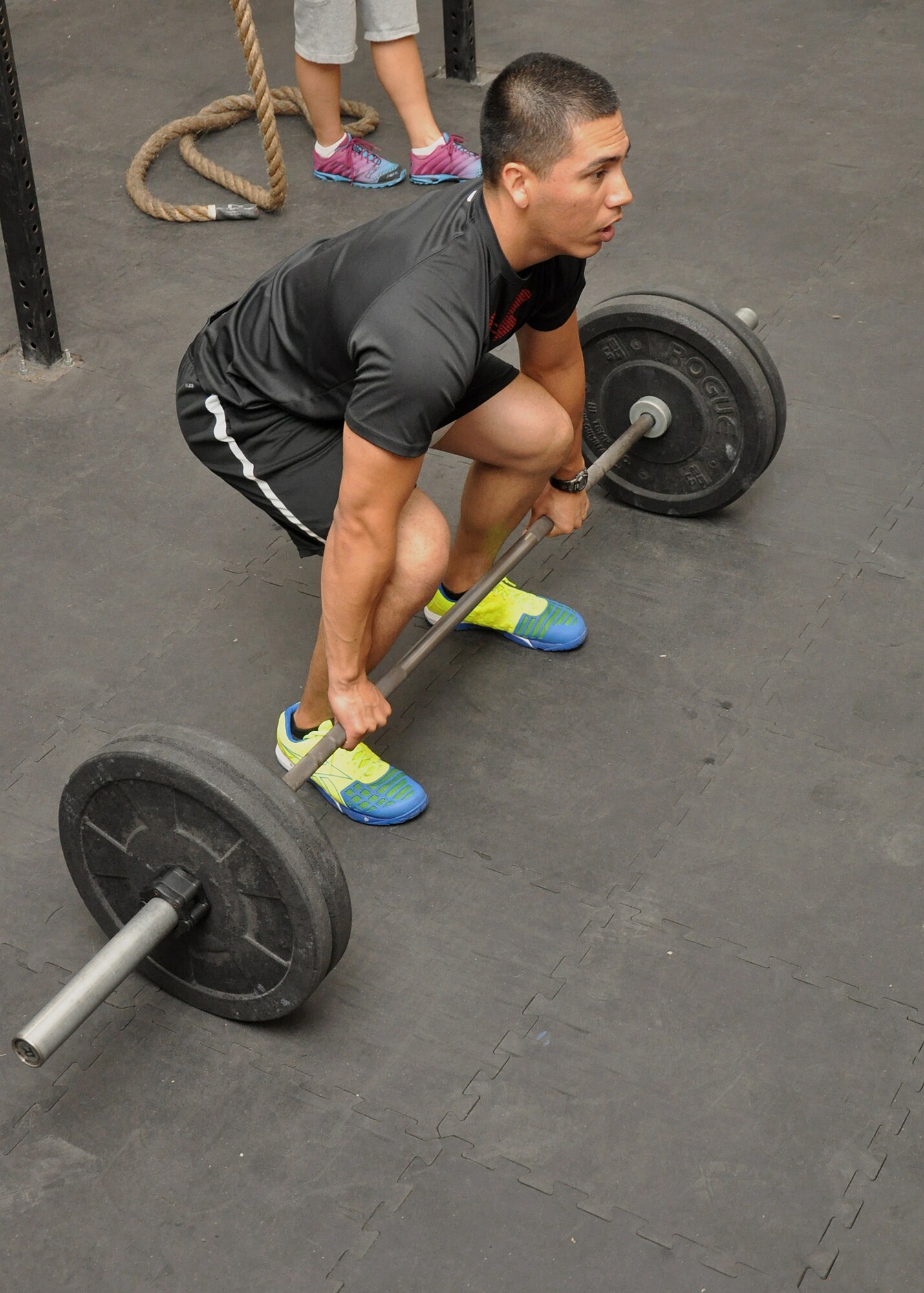 Air Force Senior Airman Emmanuel Arroyo, 380th Expeditionary Logistics Readiness Squadron supply specialist, sets himself up to perform a "clean" during a CrossFit class at the tactical fitness facility at an undisclosed location in Southwest Asia, Jan. 3, 2014. (U.S. Air Force photo by Maj. Khalid Cannon/Released)
