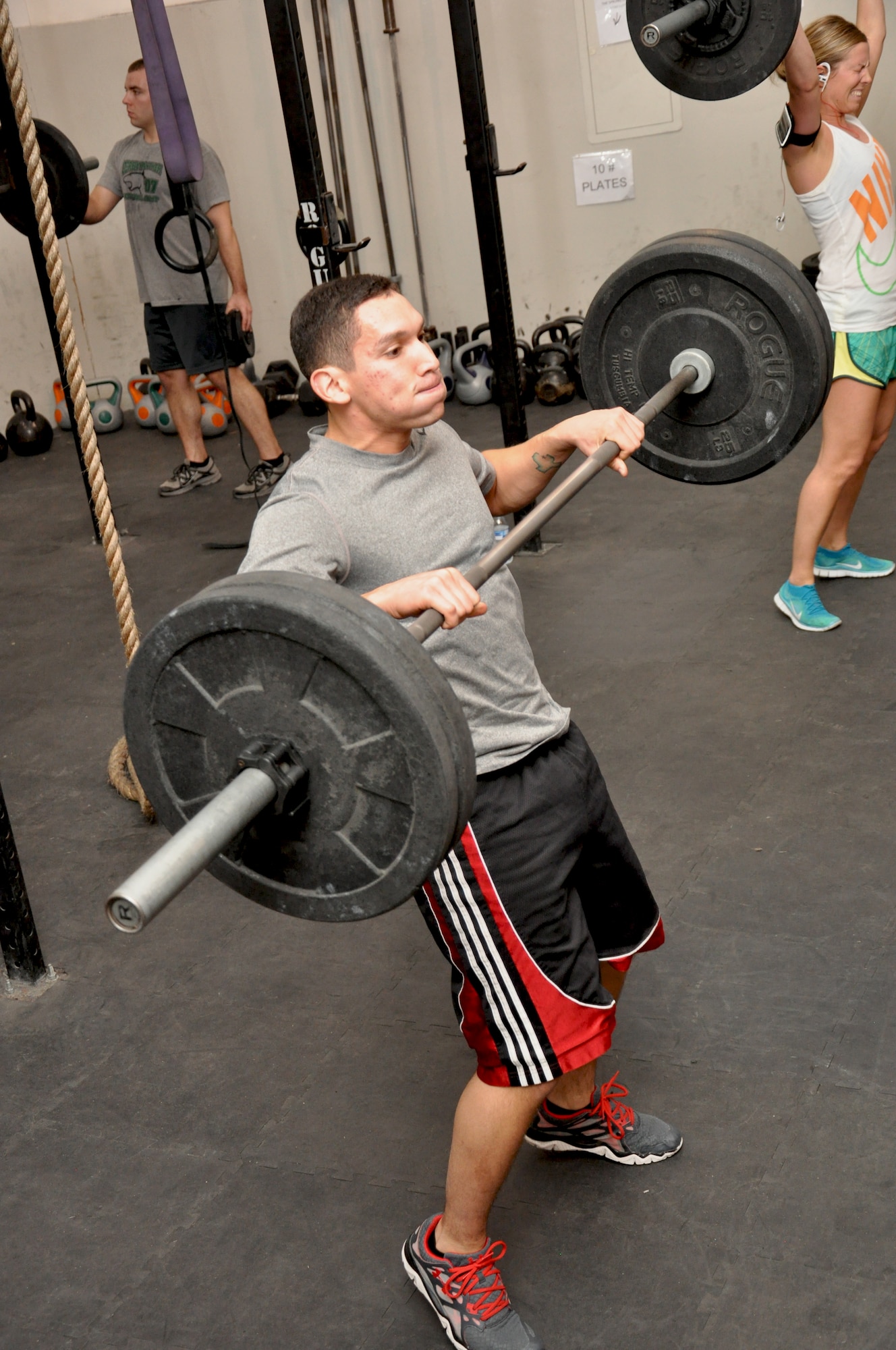 Air Force Senior Airman Carlos Amaya, 380th Expeditionary Security Forces Squadron, lifts the bar as part of a “clean” during a CrossFit class at the tactical fitness facility at an undisclosed location in Southwest Asia, Jan. 3, 2014. (U.S. Air Force photo by Maj. Khalid Cannon/Released)