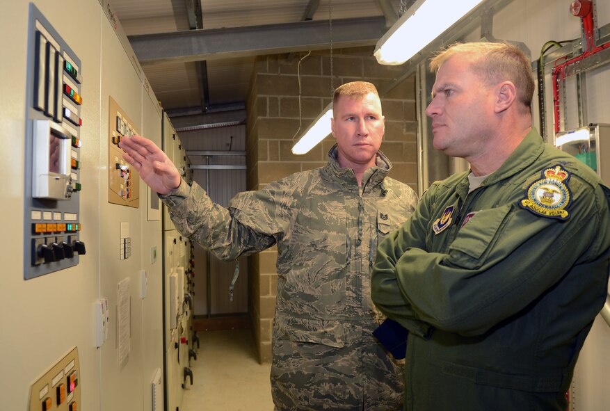 U.S. Air Force Tech. Sgt. Heath Krogmann, 100th Logistics Readiness Squadron NCO in charge of fixed facilities from Holton, Kan., left, gives U.S. Air Force Col. Kenneth T. Bibb Jr., 100th Air Refueling Wing commander, a tour of a newly renovated Type 3 Fuel Hydrant System Jan. 7, 2014, on RAF Mildenhall, England. This system is more efficient and decreases the fuel time for aircraft by 65 percent. Over time, the fuel hydrant system will prevent wear and tear on fuel service vehicles and save man hours. (U.S. Air Force photo by Airman 1st Class Kyla Gifford/Released) 