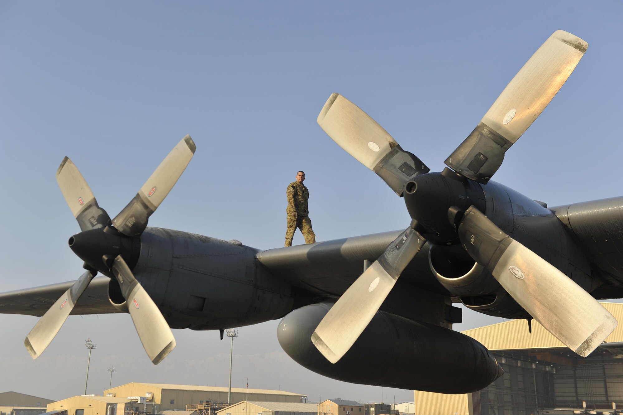 U.S. Air Force Staff Sgt. David Billings, C-130 flight engineer, does an inspection of the wings before his flight out of Bagram Airfield, Afghanistan, Jan. 9, 2013. Billings was on the first of the C-130H model aircraft to permanently relocate out of Bagram to make room for the newer C-130J model aircraft.(U.S. Air Force photo by Senior Master Sgt. Gary J. Rihn/Released)