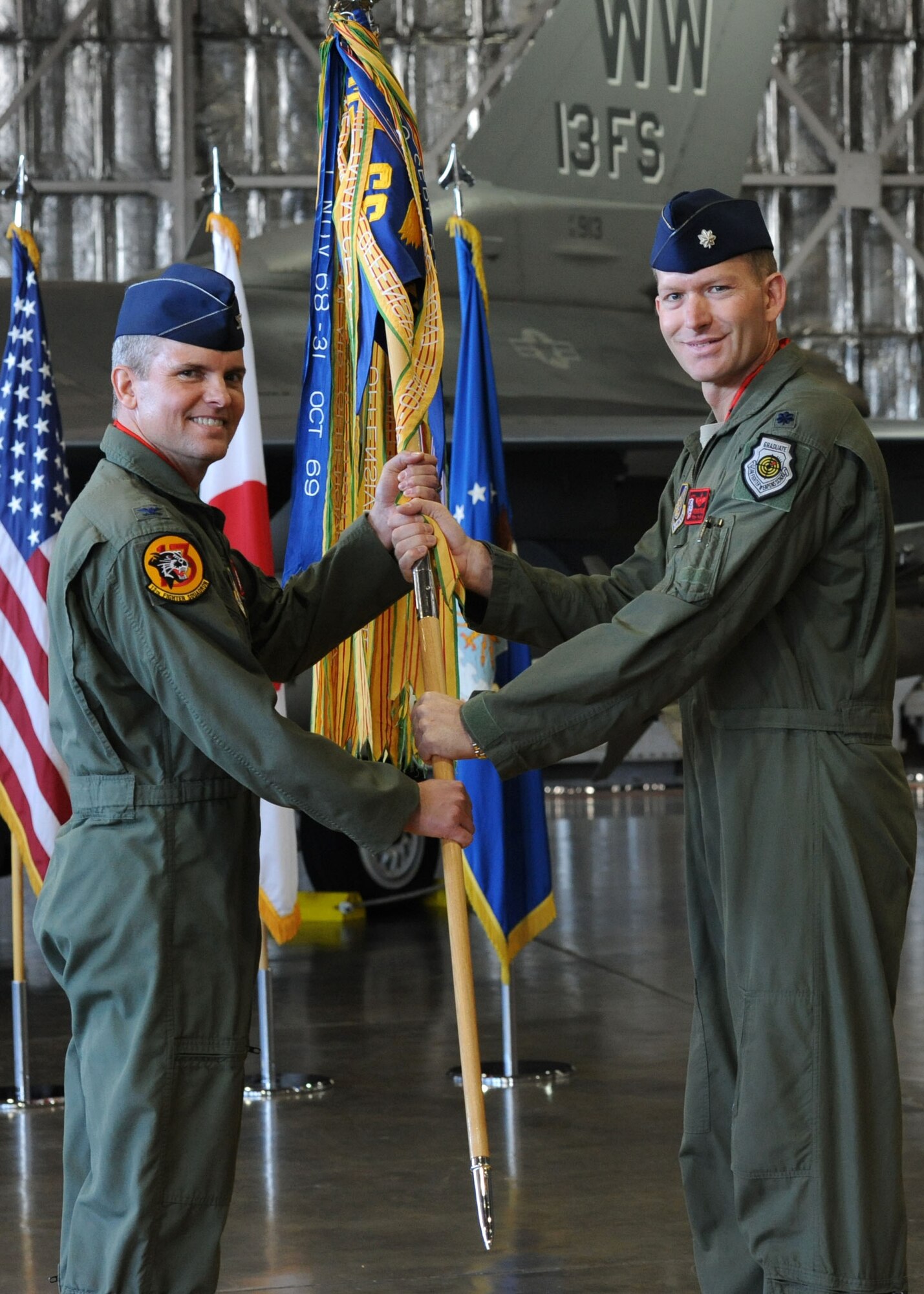 Col. John Parker, 35th Operations Group commander, passes the guidon to incoming 13th Fighter Squadron commander, Lt. Col. Kristopher Struve, during the unit’s change of command ceremony Jan. 13, 2014, at Misawa Air Base, Japan. Struve assumed command of the fighter squadron from Lt. Col. John McDaniel. Before assuming this command, Struve was the 14th Fighter Squadron assistant director and director of operations. (U.S. Air Force photo/Staff Sgt. Alyssa C. Wallace)
