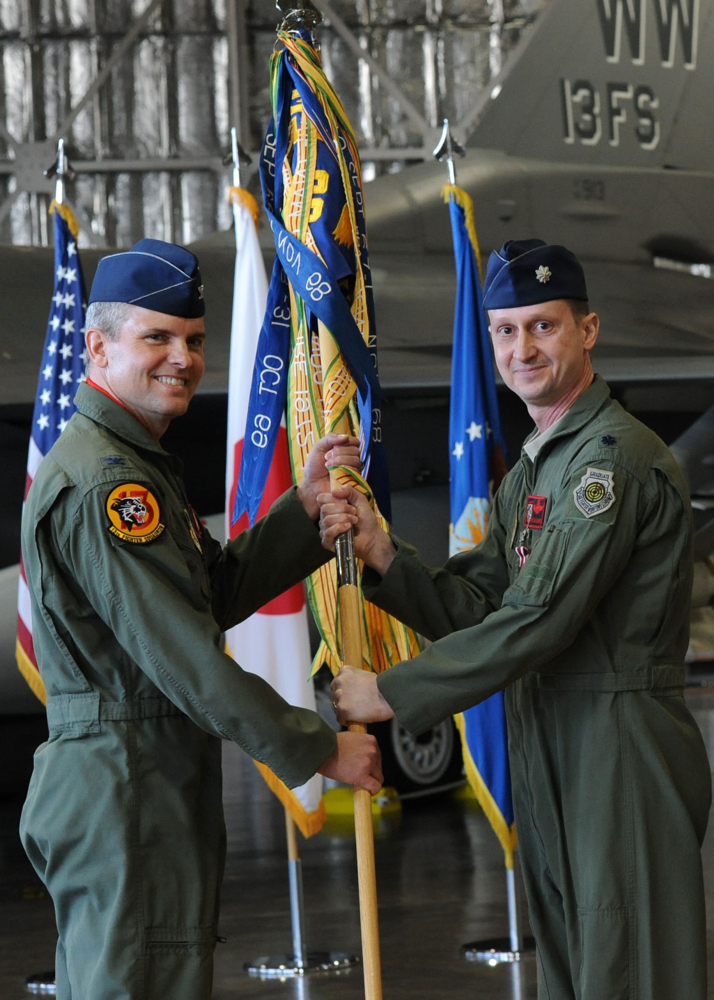 Lt. Col. John McDaniel relinquishes command of the 13th Fighter Squadron by handing the unit’s guidon to Col. John Parker, 35th Operations Group commander, Jan. 13, 2014, at Misawa Air Base, Japan. McDaniel has served as the squadron’s commander since March 2012 and earned a Meritorious Service Medal for his efforts. (U.S. Air Force photo/Staff Sgt Alyssa C. Wallace)