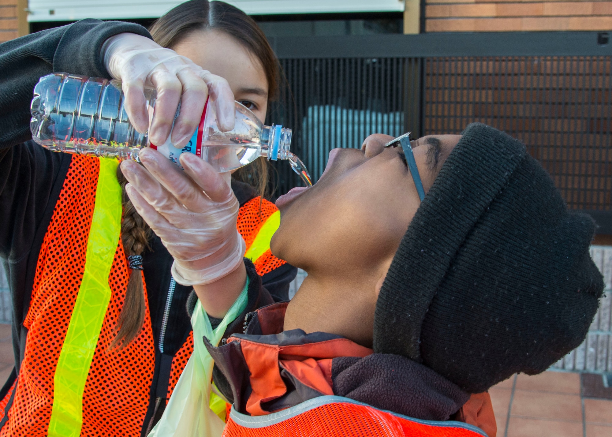 Two volunteer workers from Yokota Youth Center share a bottle of water during a community service at Fussa City, Japan, Jan. 11, 2014.  The volunteer work was a collaboration between the Fussa City Hall, and Yokota Youth and Teen Centers.  (U.S. Air Force photo by Airman 1st Class Soo C. Kim / Released)