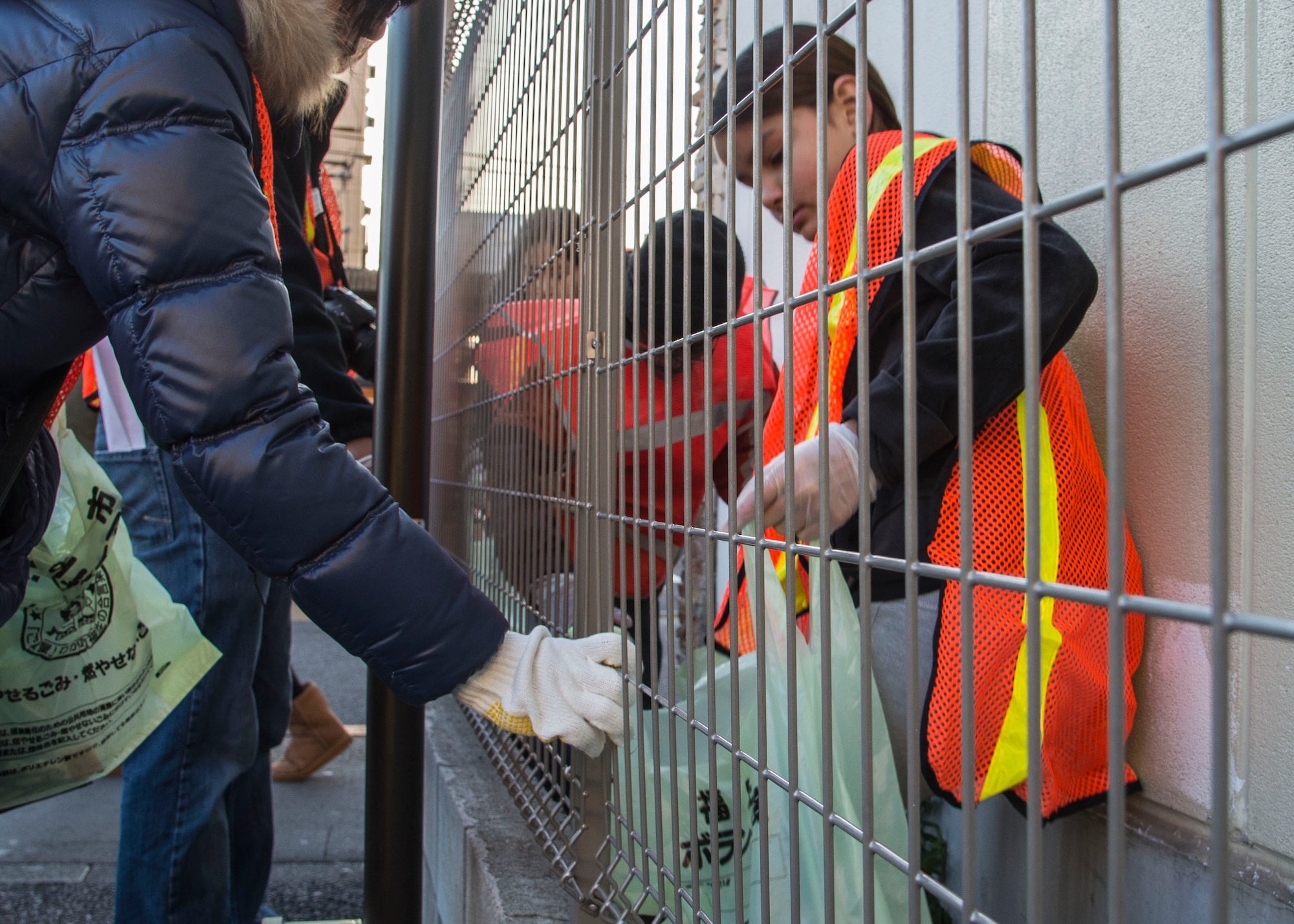 Volunteers  from Yokota Youth Center and Teen Center pick up trash in tight spaces during a volunteer cleanup honoring Martin Luther King Jr. Day at Fussa City, Japan, Jan. 11, 2014.  The cleanup was scheduled through the partnership between the Teen Center and Fussa City Hall.  (U.S. Air Force photo by Airman 1st Class Soo C. Kim / Released)