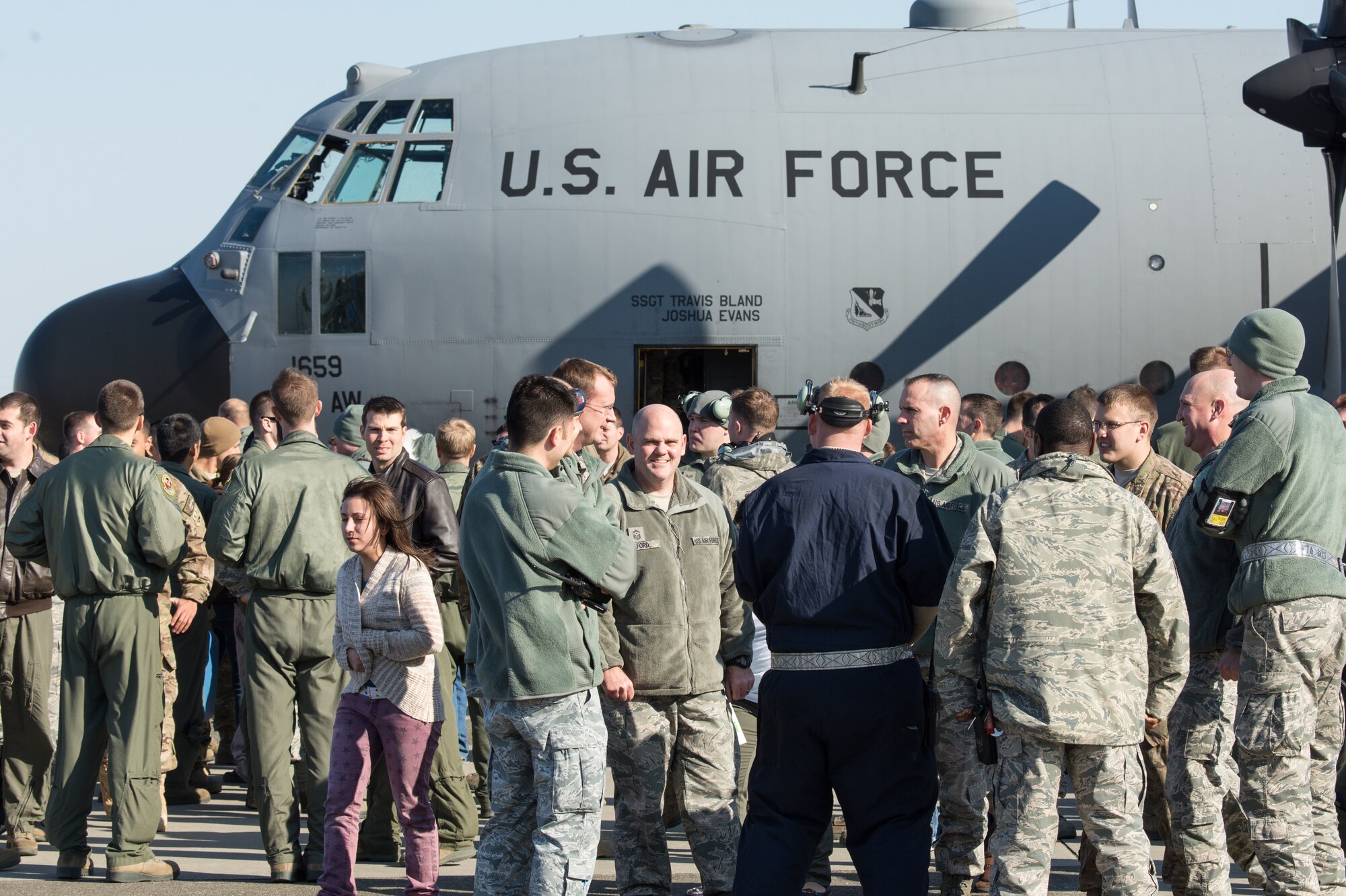 A crowd of family members, friends and co-workers await the return of Airmen from the 36th Airlift Squadron and the 374th Aircraft Maintenance Squadron at Yokota Air Base, Japan, Jan. 13, 2014. The Airmen were returning from their deployment to Southwest Asia. (U.S. Air Force photo by Osakabe Yasuo/Released)