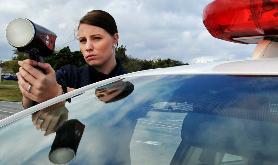 U.S. Air Force Senior Airman Sarah Oswald, 18th Security Forces Squadron Tango unit patrolman, uses a speed-detecting radar gun to measure how fast cars are going during a daily traffic control on Kadena Air Base, Japan, Jan. 10. Members of the 18th SFS conduct traffic control every day along with Japanese civilian guards, using radar to detect speeding vehicles. (U.S. Air Force photo by Naoto Anazawa)