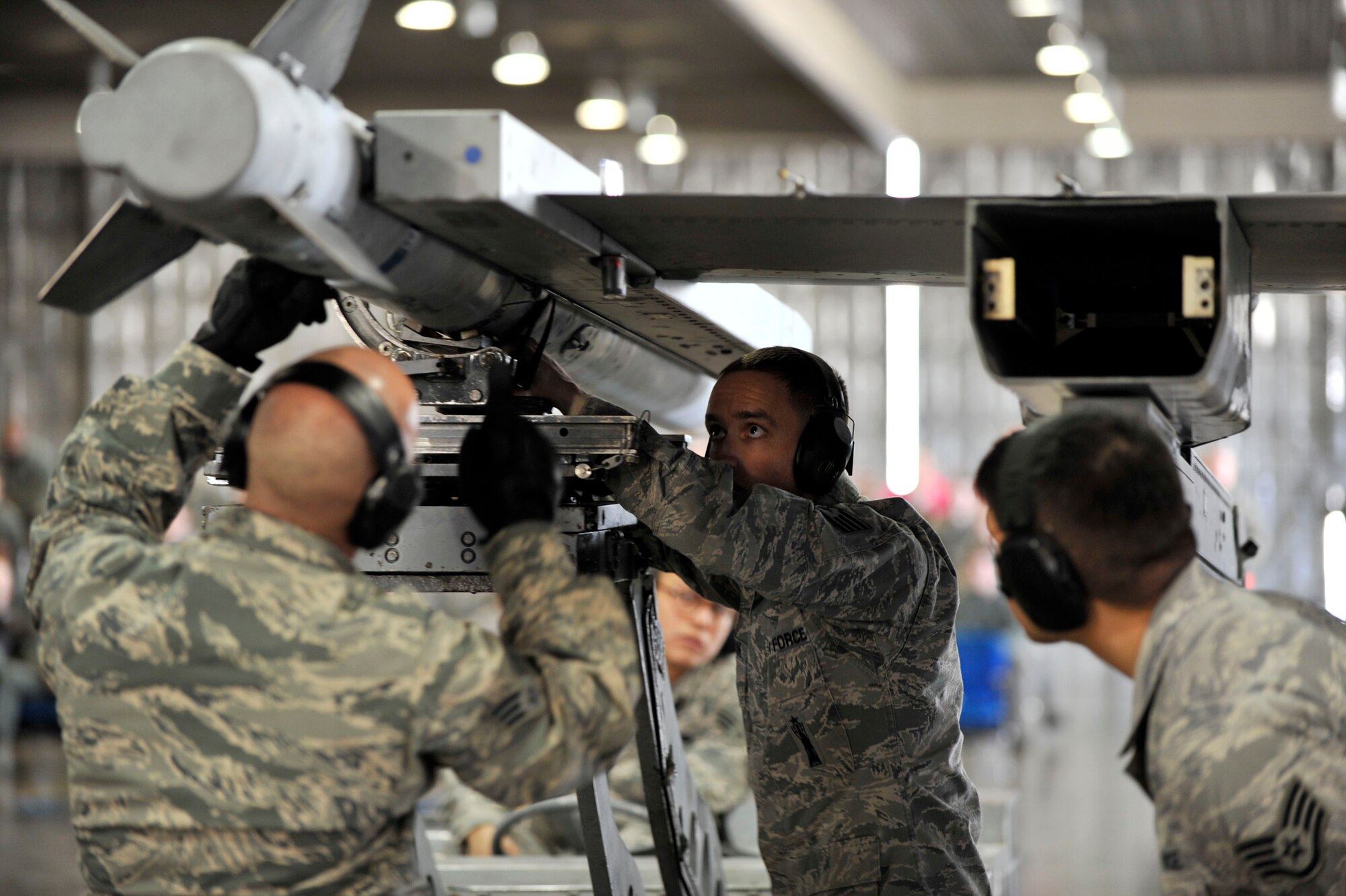 MISAWA AIR BASE, Japan – Staff Sgt. Derek Pascoe, 13th Aircraft Maintenance Unit load crew chief aligns an AIM-120 advanced medium-range air-to-air missile with the assistance of his crew for the 4th Quarter Load Crew Competition at Misawa Air Base, Japan, Jan. 10, 2014. The 13 AMU defeated their 14 AMU rival with the best overall combined scored in four distinct categories: dress and appearance inspection, composite tool kit inspection, a written test, and the best weapons load with the least discrepancies. (U.S. Air Force Photo by Staff Sgt. Tong Duong)