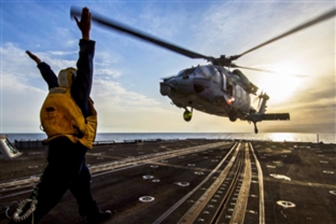 U.S. Navy Petty Officer 2nd Class Shane Hempfield signals the pilot of an MH-60S Seahawk helicopter to launch from the flight deck of the guided-missile cruiser USS San Jacinto in the Arabian Gulf, Jan. 5, 2014. The San Jacinto is supporting maritime security operations and theater security cooperation efforts in the U.S. 5th Fleet area of responsibility. 