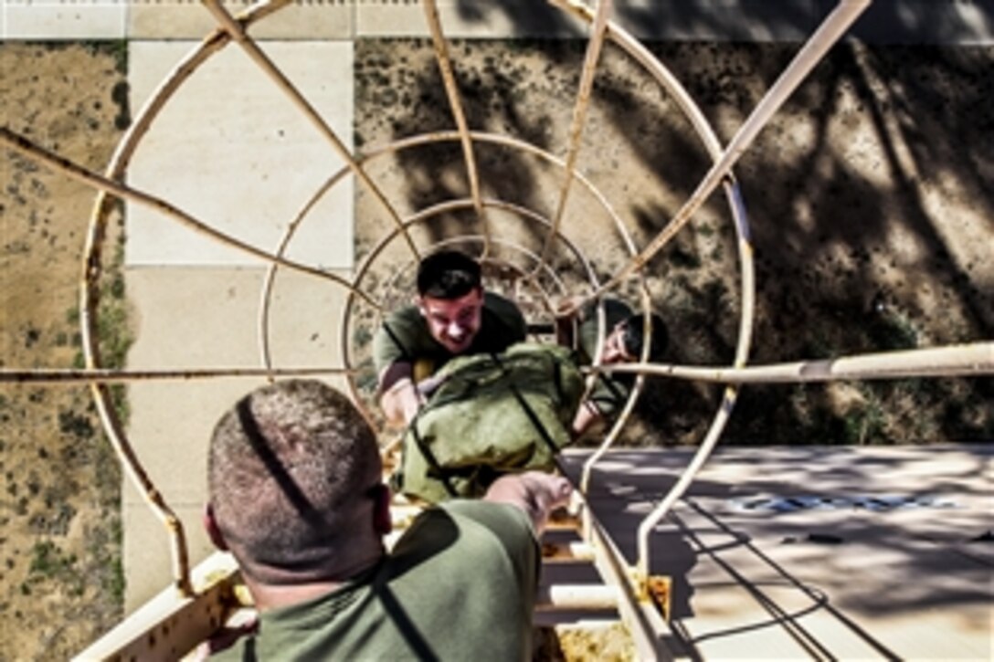 Marine Corps Sgt. Jonathan Ayala hands radio antenna equipment to Marine Corps Staff Sgt. Christopher M. Phibbs during a communications exercise to prepare the Marines for Exercise Iron Fist on Camp Pendleton, Calif., Jan. 6, 2014. Ayala, a cyber network operator, and Phibbs, a cyber network chief, are assigned to the 15th Marine Expeditionary Unit.