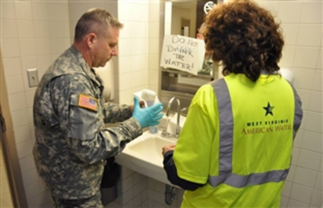 A member of West Virginia National Guard’s chemical, biological, radiological, nuclear and high-yield explosive enhanced response force package draws a water sample to determine the levels of contamination remaining in the local water supply during Operation Elk River Spill in the Kanawha Valley, W. Va., Jan. 11, 2014.