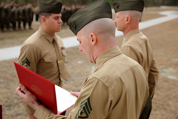 Sgt. Maj. Rodger D. Newcomb, the sergeant major of 2nd Supply Battalion, 2nd Marine Logistics Group reads the Navy Commendation Medal citation during an award ceremony aboard Camp Lejeune, N.C., January 10, 2014. Cpl. Brian E. Babineau, a Gardner, Mass., native and a warehouse clerk with Supply Company, 2nd Supply Bn., 2nd MLG, received the award for saving a young girls life at North Topsail Beach on July 14, 2013 when she was being pulled away farther out to sea by a strong rip current. 