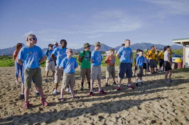 Young Marines stand at parade rest at Fort Hase Beach while Lance Bookless, the senior natural resources manager at the Environmental Compliance and Protection Department, gives a brief, Dec. 4, 2013. More than 20 Young Marines from units in Florida, Kentucky and Washington joined the Pyramid Rock Young Marines and active-duty Marines to clean the beach. Young Marine units annually travel to Hawaii to commemorate the anniversary of the Dec. 7 attacks by participating in a parade and wreath laying. This year they also participated in the basewide clean-up, Malama Ka Aina. Young Marine Sgt. Maj. Dakota Richter, the National Young Marine of the Year, from Florence, Ky., said the beach clean-up was the best form of community service and the group is grateful for the base’s hospitality. Young Marine Sgt. Maj. Storme DiGiovanni, 17, of Kailua, said the clean-up was a great opportunity for the Young Marines to come together for an activity, especially helping preserve the nature of Hawaii’s beaches. (U.S. Marine Corps photo by Kristen Wong)