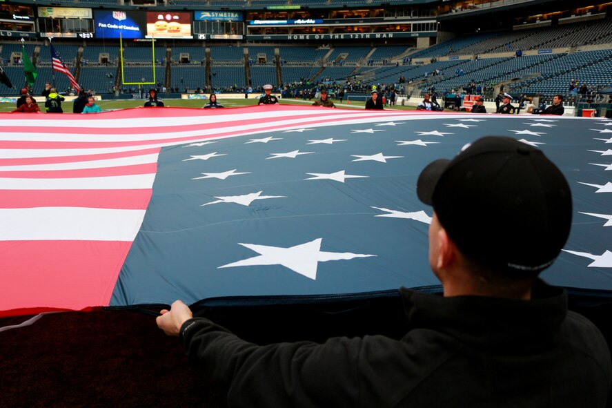 Reservists from the 446th Airlift Wing, along with their active-duty counterparts and members of the other service branches, practice presenting the U.S. flag prior to the Seattle Seahawks NFC Divisional game against the New Orleans Saints, Jan. 11 at Century Link Field in Seattle, Wash.  The home team won the divisional round and is set to hold the NFC Championship Game, Jan. 19. (U.S. Air Force photo by Senior Airman Madelyn McCullough)