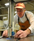 Michael Cain, 92nd Force Support Squadron woodcraft staff, operates the band saw in the wood craft center at Fairchild Air Force Base, Wash., Jan. 13, 2014. Cain is refining his skills in constructing a pen to help him instruct students on the course. (U.S. Air Force photo by Airman 1st Class Ryan Zeski/Released)