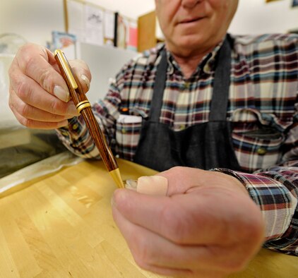 Timothy Bailey, 92nd Force Support Squadron woodcraft staff, displays a pen students are able to make during a class held at the wood craft center at Fairchild Air Force Base, Wash., Jan. 10, 2014. Bailey is the main instructor for the pen crafting course. (U.S. Air Force photo by Airman 1st Class Ryan Zeski/Released)