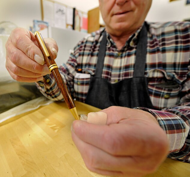 Timothy Bailey, 92nd Force Support Squadron woodcraft staff, displays a pen students are able to make during a class held at the wood craft center at Fairchild Air Force Base, Wash., Jan. 10, 2014. Bailey is the main instructor for the pen crafting course. (U.S. Air Force photo by Airman 1st Class Ryan Zeski/Released)
