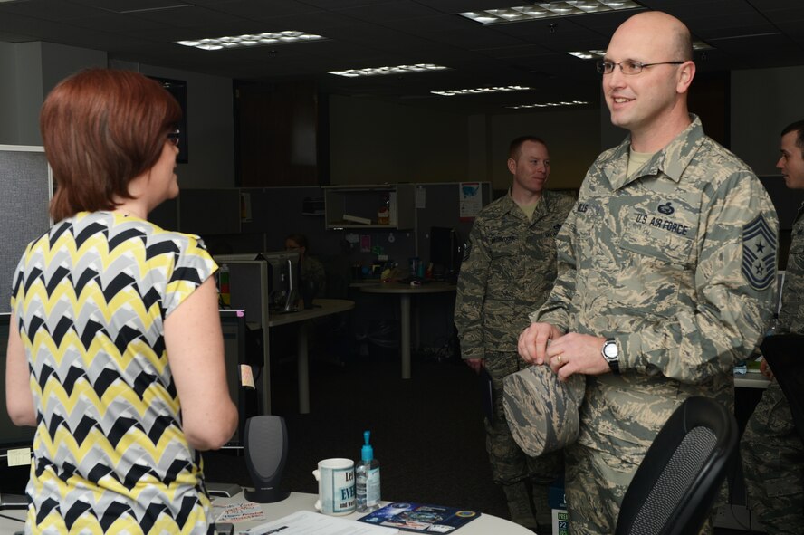 U.S. Air Force Chief Master Sgt. Mills (right), 20th Fighter Wing command chief, converses with Llawayne Reid (left), 20th Comptroller Squadron civilian pay technician, in the finance office at Shaw Air Force Base, S.C., Jan. 13, 2014. Mills talked to personnel asking about their jobs and introduced himself to the Air Force civilian employees. (U.S. Air Force photo by Airman 1st Class Diana M. Cossaboom/Released)
