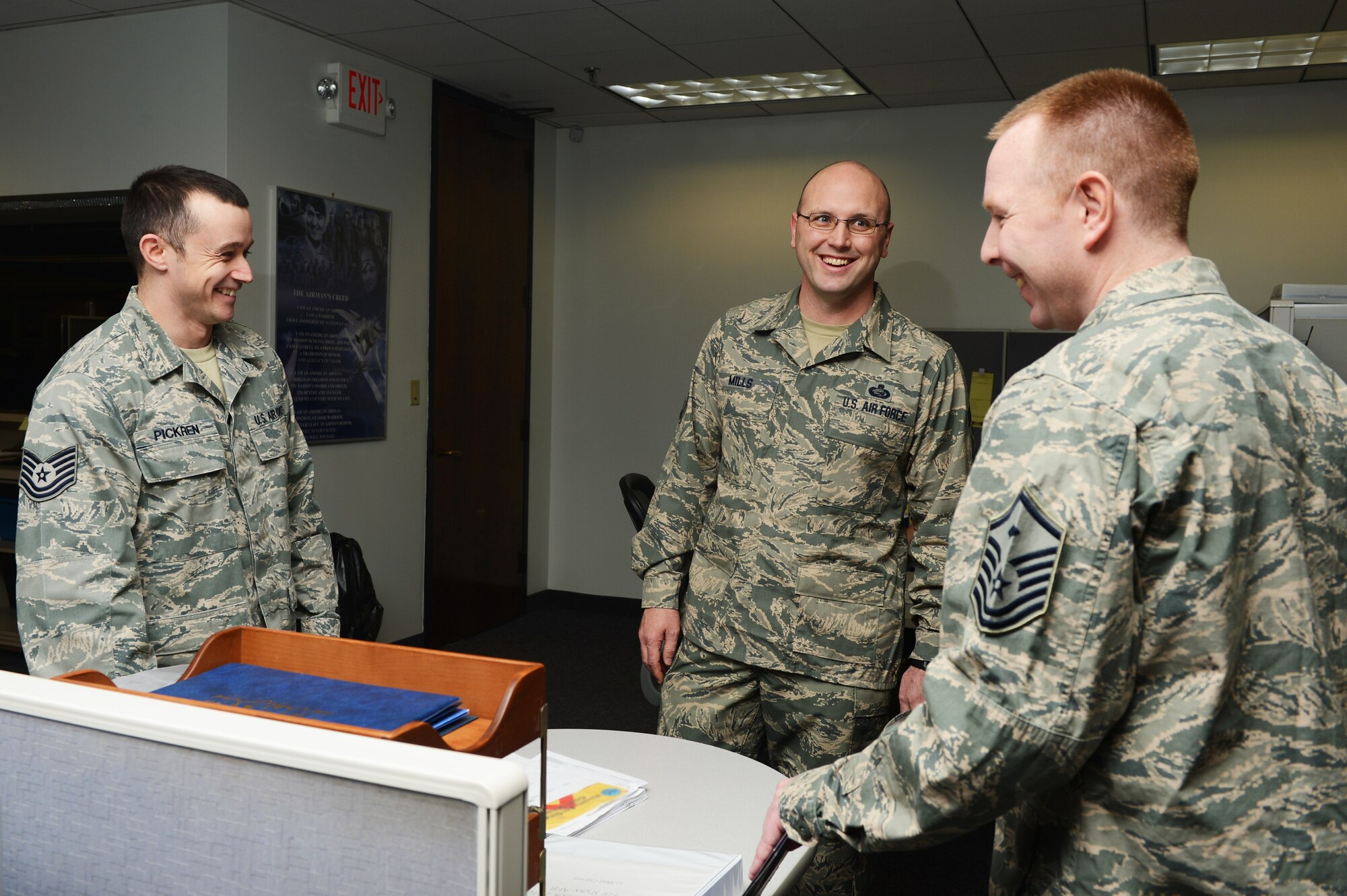 U.S Air Force Chief Master Sgt. Mills (middle), 20th Fighter Wing command chief, converses with Tech. Sgt. Jason Pickren (left), 20th Comptroller Squadron NCOIC of customer service, and Master Sgt. Jeffrey Vanstrydonk (right), 20th CPTS first sergeant, in the finance office at Shaw Air Force Base, S.C., Jan. 13, 2014. As the new command chief, Mills introduced himself to several Airmen and asked them questions to get to know them better. (U.S. Air Force photo by Airman 1st Class Diana M. Cossaboom/Released)