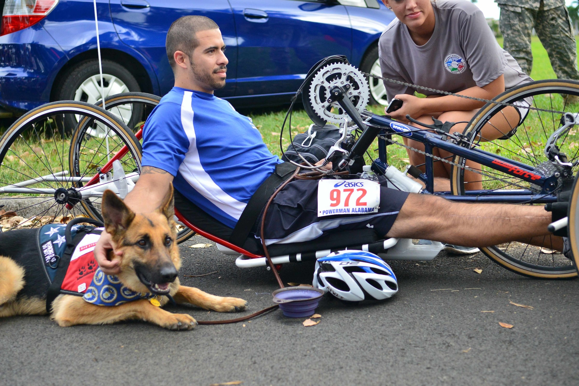 Joined by his service dog, Kai, Staff Sgt. August O’Niell, 58th Rescue Squadron Pararescue jumper, listens to instructions before the inaugural Wounded Warrior Pacific Invitational cycling time trials, Jan. 8, at Joint Base Pearl Harbor-Hickam, Hawaii. O’Niell suffered gunshot wounds during a rescue mission in Afghanistan on Jul. 15, 2011. Athletes from all services are here to compete in the 2014 Wounded Warrior Pacific Invitational, which features more than 120 wounded-warrior athletes competing in cycling, track and field, seated volleyball, swimming and wheelchair basketball. The WWPI is an adaptive sports training camp preparing service members, who’ve fallen ill or were injured in the line of duty, for competition in the United States Olympic Committee's Warrior Games, held at the  U.S. Olympic Training Center and the United States Air Force Academy in Colorado Springs, Colo. (U.S. Air Force photo by Senior Airman Christopher Stoltz)
