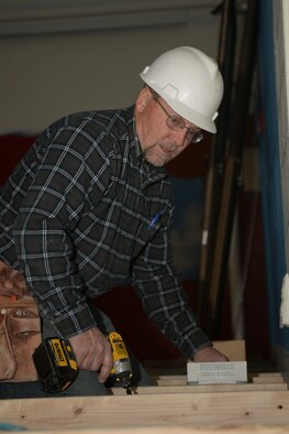 Gary Marker, GBK Joint Venture quality control supervisor, builds a wooden platform in the Bellamy Fitness Center at Ellsworth Air Force Base, S.D., Jan. 6, 2014. The platform will create a pathway for electrical support to cardio machines. (U.S. Air Force photo by Airman 1st Class Rebecca Imwalle/ Released) 