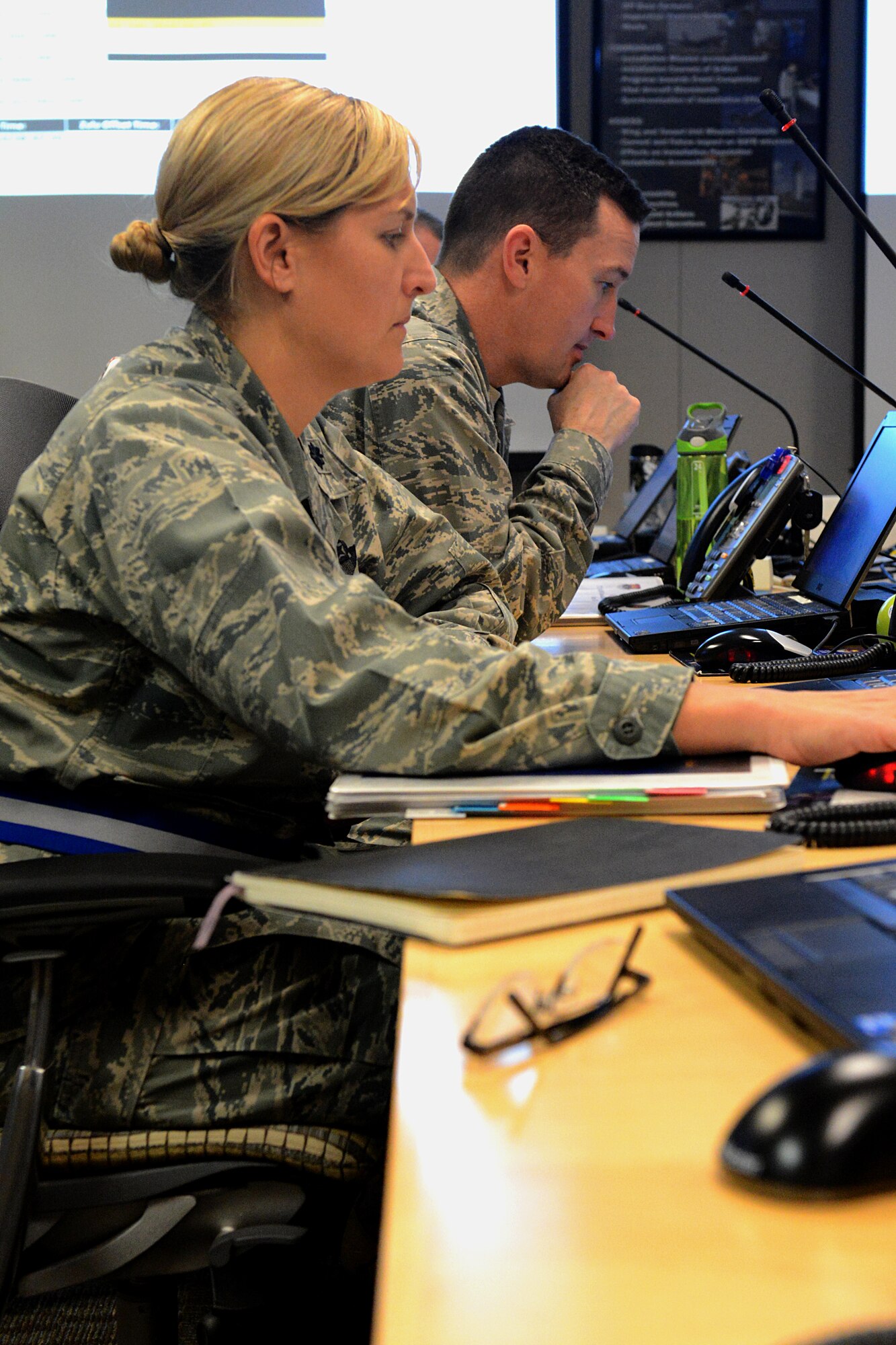Lt. Col. Allison Trinklein and Col. Bret Burton look over material at the Crisis Action Team center during the wing’s mobility exercise Jan. 11, 2014, Scott Air Force Base, Ill. The exercise provided an opportunity to test capabilities and procedures while ensuring Airmen maintain readiness to support Department of Defense operations. Trinklein is the 458th Airlift Squadron commander and Burton is the 375th Medical Group commander. (U.S. Air Force photo/Senior Airman Jake Eckhardt)