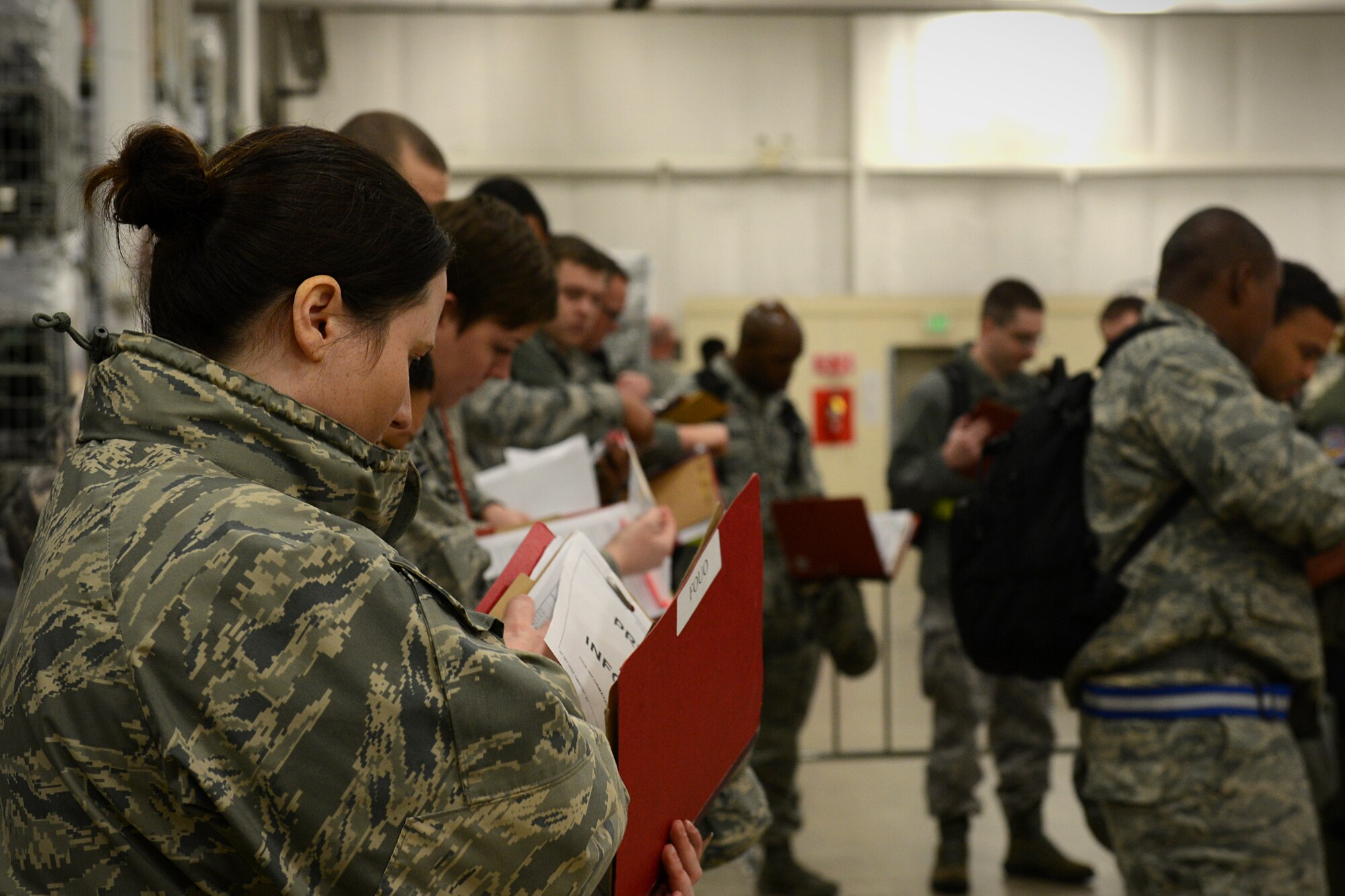 Members participating in the exercise get their dogtags out and prepare their records for inspection Jan. 11, 2014 at Scott Air Force Base, Ill. The exercise evaluated the 375th Air Mobility Wing's ability to process personnel and cargo for contingencies. (U.S. Air Force photo/Senior Airman Jake Eckhardt)